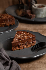 Piece of chocolate  no bake mousse cake with raisins on dark background, close up. Vertical image.