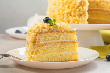 A piece of Italian sponge cake - Mimosa cake,  decorated with blueberries and mint. Close-up.