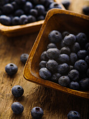 Close-up. Lots of fresh blueberries in bowls and on the table. Rough wooden texture. Country style. Delicious vegetarian food. Cooking. Healthy lifestyle. Environmental protection.
