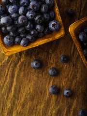 Blueberries in yellow square bowls and in bulk on the table. Harvest Day. Agriculture, farming, forestry. Delicious healthy vitamin product. Close-up. High angle view.