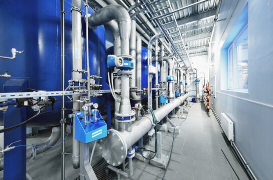 Large blue tanks in a industrial city water treatment boiler room. Wide angle perspective. Technology, chemistry, heating, work safety, supply, infrastructure