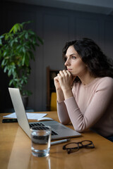 Distracted from work pensive young woman sit with laptop think of problem. Thoughtful unmotivated...
