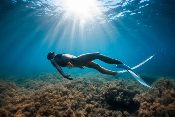 Free diver woman with white fins posing underwater. Freediving with young girl