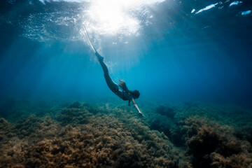 Freediver girl underwater in ocean