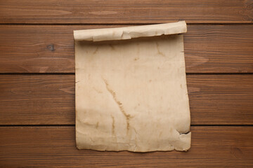 Sheet of old parchment paper on wooden table, top view. Space for design