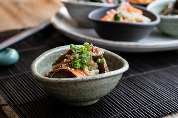 Japanese vegetable salad with sesame seeds and green onions, placed over bamboo mat.