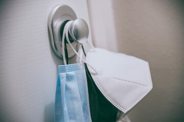 Group of surgical masks hung on the home door handle. Closeup view of face mask during coronavirus...