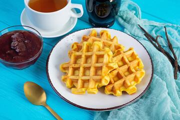 Sweet pumpkin waffles with strawberry jam. Delicious breakfast with belgian waffles