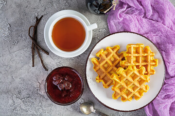 Sweet pumpkin waffles with strawberry jam. Delicious breakfast with belgian waffles. Top view