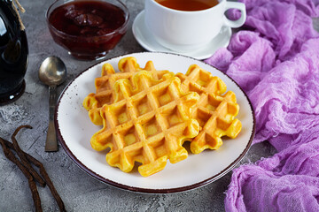 Sweet pumpkin waffles with strawberry jam. Delicious breakfast with belgian waffles