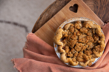 Homemade mini apple crumble pie on cutting board with a heart shaped cutout