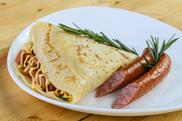 Pancake with sliced sausage and mustard