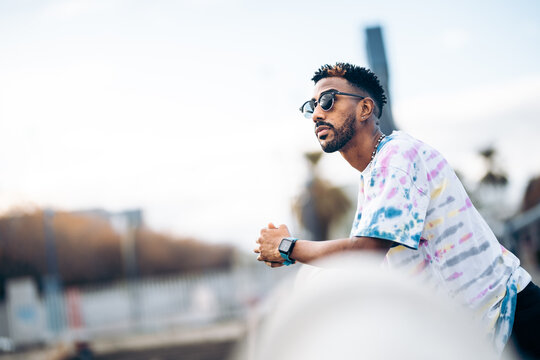 Black Man With Sunglasses Leaning On The Railing Of A Bridge Pensive And Relaxed