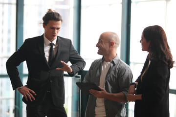 team young business people working and communicating while standing at the office with city building background.