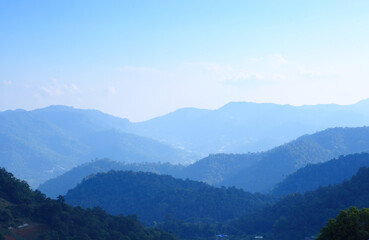 Mountain range with visible silhouettes through the morning colorful fog.with sunlight romanctic moment