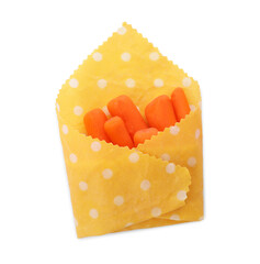 Many baby carrots in beeswax food wrap on white background, top view
