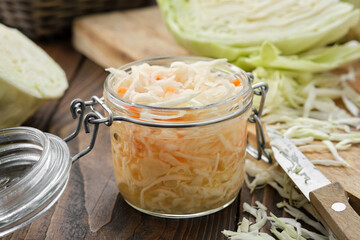 Jar of sour cabbage, pickled sauerkraut. Fermented cabbage, coleslaw salad. Chopped cabbage on a cutting board for making sauerkraut on background. Healthy food, diet food. - obrazy, fototapety, plakaty