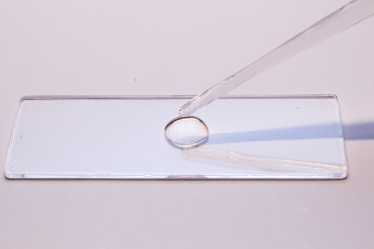 glass and syringe with clear solution 