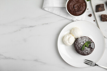 Delicious fresh fondant with hot chocolate, mint and ice cream served on white table, flat lay....