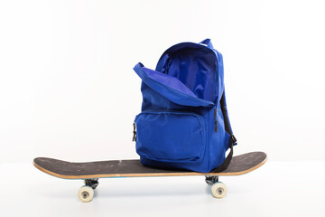 Fototapeta Blue open backpack sitting on skateboard, back to school concept obraz
