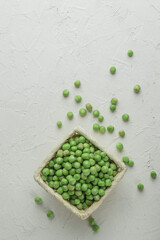 Top view Ripe pods of green peas on light concrete background. Fresh vegetables. Legumes. Flat lay.