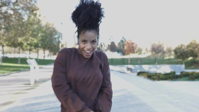 Happy young hispanic latin woman having fun dancing in the street and following the camera. High quality 4k footage