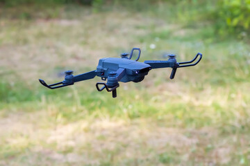 Launching a drone. The drone takes off from the platform above the grass in the summer.