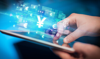 Close-up of a hand using tablet, currency concept