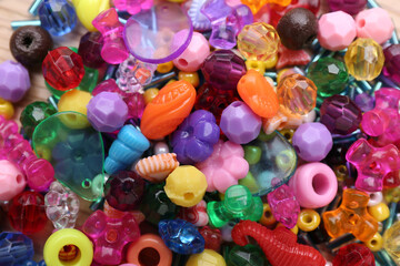Fototapeta na wymiar Many different bright beads as background, top view