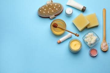 Flat lay composition with beeswax and cosmetic products on light blue background. Space for text