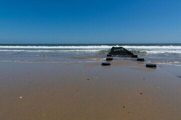 beach and sea with abandoned pier leading out to the horizon. Representation of a path to the future or the unknown.