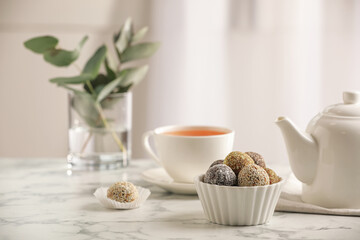 Different delicious vegan candy balls on white marble table indoors