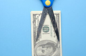 A picture of scissors on fake money for financial cut concept.