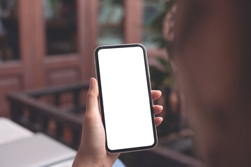 Cell phone mockup image blank white screen.  Woman hand holding, using mobile phone at home.