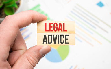 Plakat Cropped view of hands holding wooden cube with LEGAL ADVICE lettering on work table. Top view