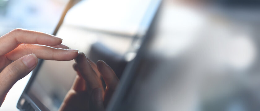 Close up, woman hand using digital tablet and finger touching on the screen to search online content