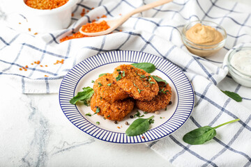 Plate with tasty lentil cutlets on table
