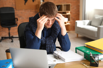 Tired young man working with documents in office