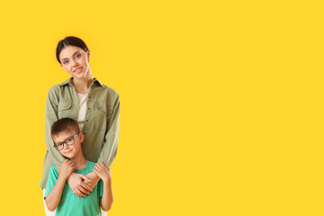 Little boy with his older sister on yellow background