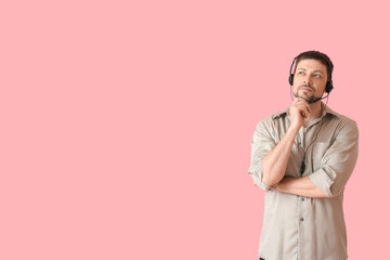 Thoughtful consultant of call center in headset on pink background