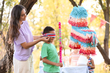 Woman and her little son at pinata birthday party