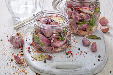 Homemade pickled garlic with salt, allspice, bay leaf.