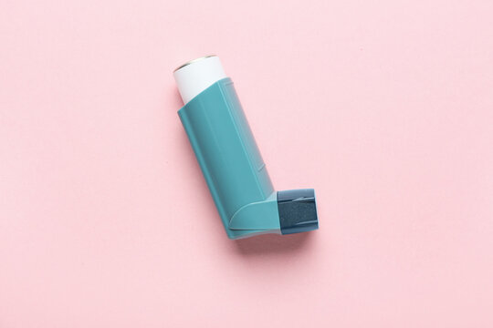 Modern asthma inhaler on color background