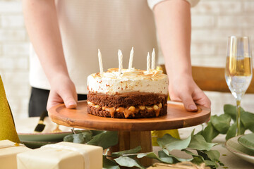 Woman with tasty birthday cake on table