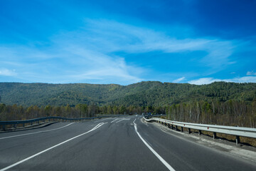 A landscape with a winding highway under a cloudy sky.