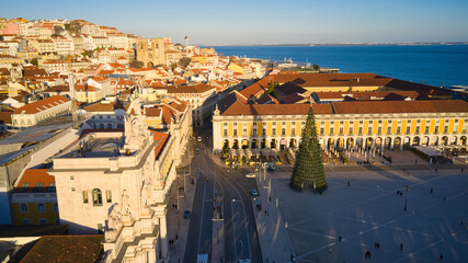 Lisbon, Portugal - January 13, 2022: Aerial drone view of the Augusta Street Arch from Commerce Square in Lisbon, Portugal. Christmas tree in the plaza. Winter sunset.