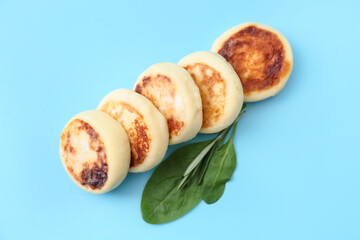 Tasty cottage cheese pancakes on blue background
