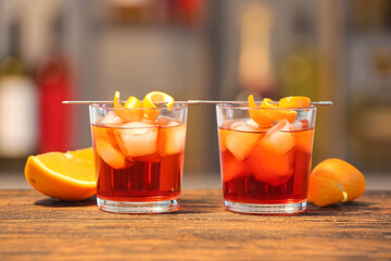 Glasses of tasty Negroni cocktail on table against blurred background