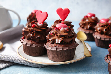 Plate with tasty chocolate cupcakes for Valentine's day on color background, closeup
