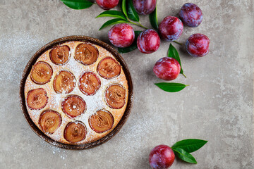 Colorful soft sponge cake with red plum. Top view.